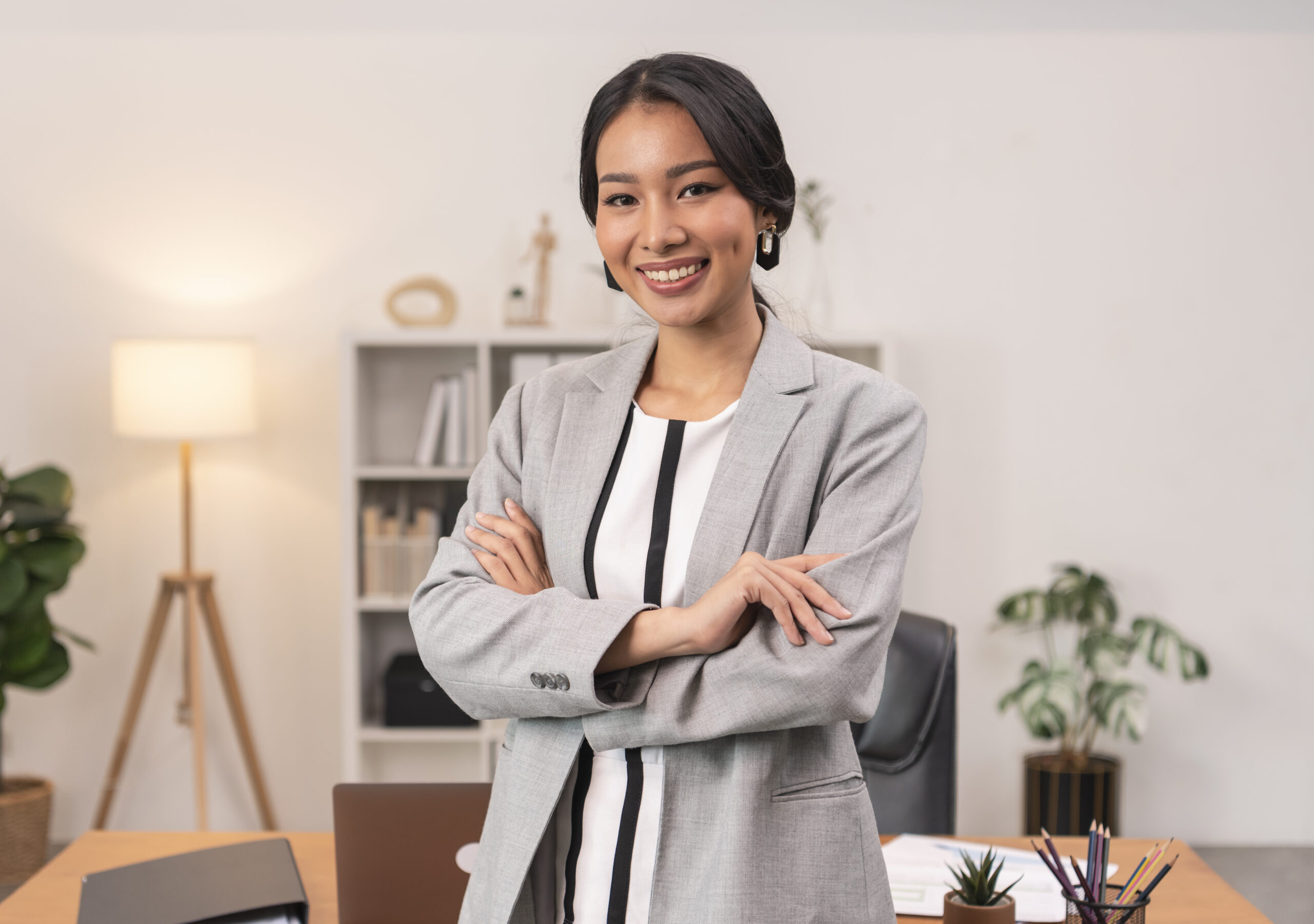 Executive Asian businesswoman smiling and crossed arms in office.